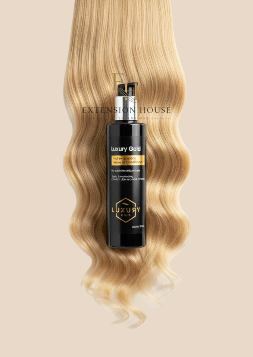 Extension house Luxury Gold leave-in conditioner voor hairextensions op een achtergrond van blond haar.