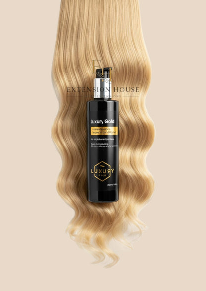 Extension house Luxury Gold leave-in conditioner voor hairextensions op een achtergrond van blond haar.
