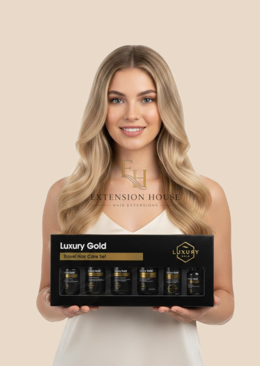 Vrouw met blond haar houdt Extension house Luxury Gold 6-delige reisset voor hairextensions vast in luxe verpakking.