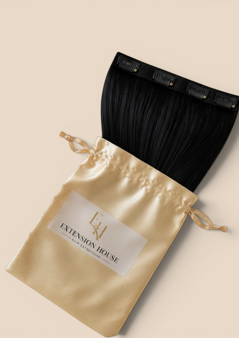 Extension house zwarte human hair flip-in extensions in luxe satijnen opbergzakje voor extra volume en lengte.